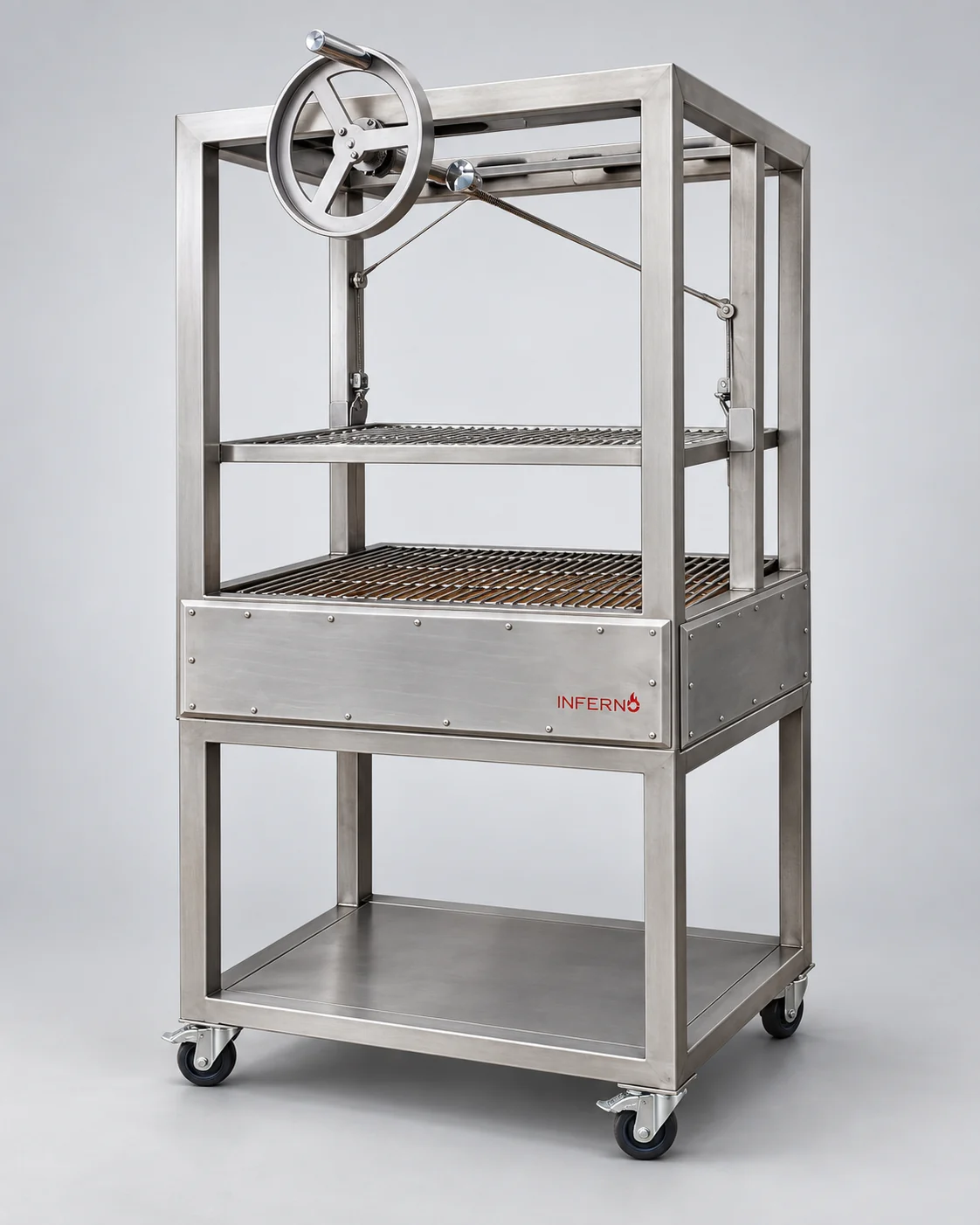 The Basque Parrilla on its stand, at an angle: the crank wheel and frame above the grids over the fire box, an Inferno logo on the front, and a shelf on the stand below, on castors.