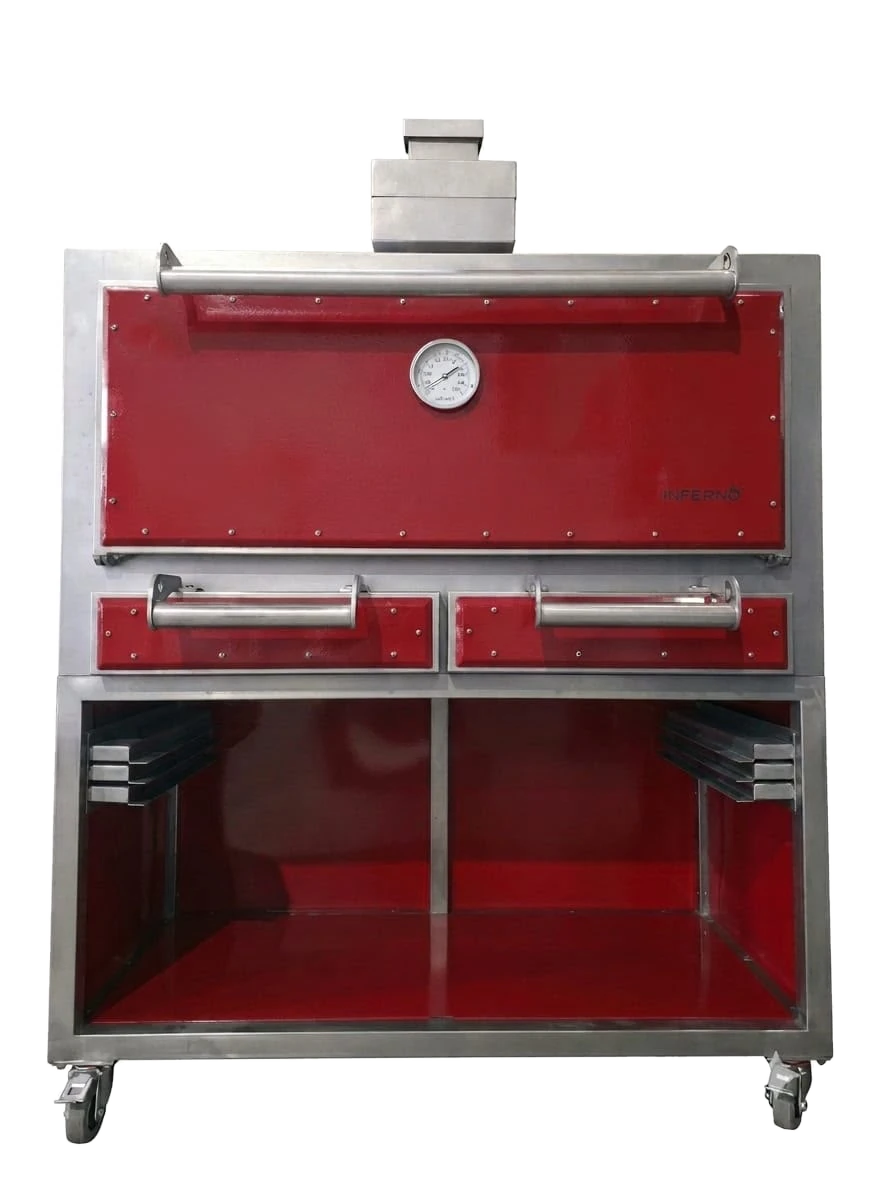 The Inferno 1200 from the front on its stand: a red door with a thermometer over two red drawers in a stainless frame, the stepped firebreak and diffuser chimney on top, and a divided red-lined stand with grid storage at each side, on castors.